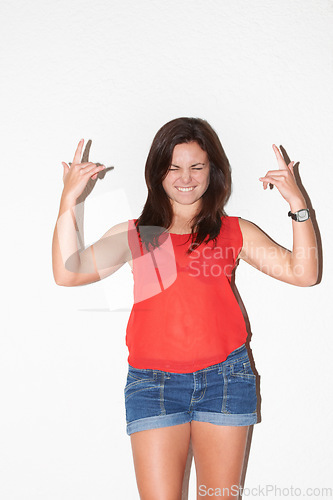 Image of Fashion, rock sign and confident woman on a white background with hand gesture, signal and emoji. Culture, attitude and isolated person in trendy clothes, casual outfit and style for punk in studio