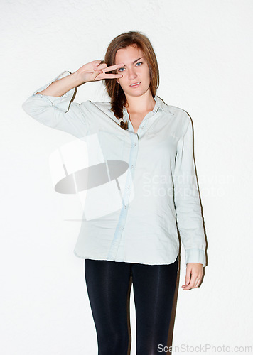 Image of Fashion, peace sign on eyes and portrait of woman on a white background with confidence, pride and emoji. Serious, hand sign and isolated person in trendy clothes, casual outfit or style in studio