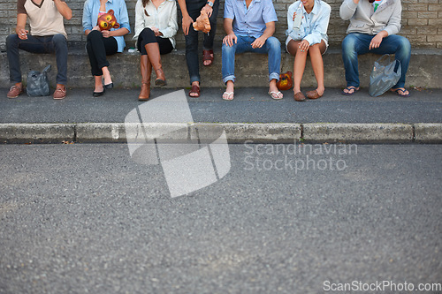 Image of Low, street and legs of people in the city for bonding, social and community event. Urban, together and friends or a group sitting on the sidewalk of the road for solidarity, party or society
