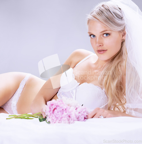 Image of Portrait, woman and bride with flowers, lingerie and beauty with intimacy on a white studio background. Person, model and girl with a bouquet, underwear and veil with plants, luxury and marriage