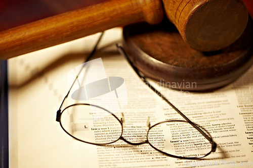 Image of Table, law and a report, glasses and gavel for a court decision, notes or a justice report. Closeup, desk and paperwork or a dictionary for legal knowledge, courtroom words or a crime defense