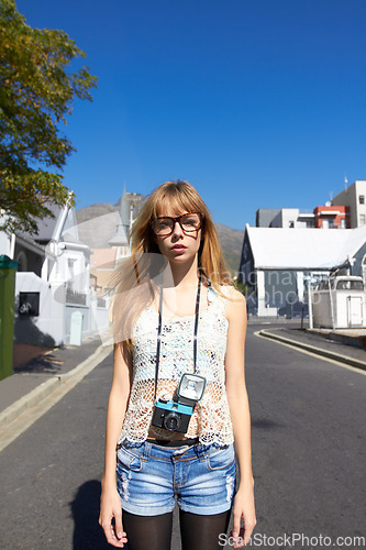 Image of City, photographer and portrait of serious woman with camera for creative and art career traveling. Gen z, paparazzi and young female person from Australia with dslr equipment for vacation in town.