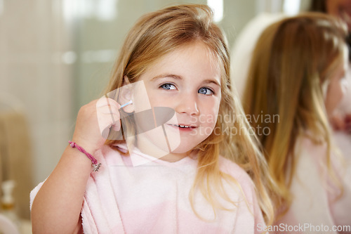 Image of Grooming, hygiene and a child cleaning ears with an earbud in a home bathroom for sanitation. Smile, mirror and a girl or young kid learning to clean body during morning routine and getting ready