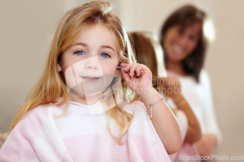 Image of Portrait, hygiene and a child cleaning ears with an earbud in a home bathroom for grooming. Smile, cotton and a girl or young kid learning to clean body during morning routine and getting ready