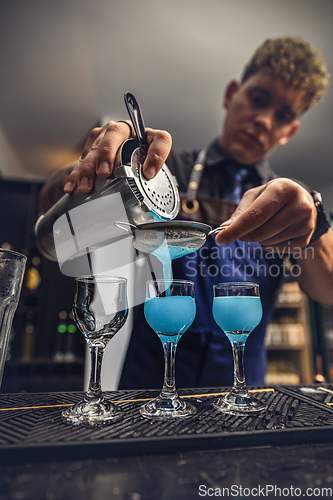 Image of Bartender pouring fresh blue cocktail