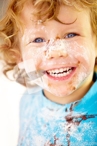 Image of Portrait, mess and flour with a boy in the kitchen of his home, learning how to cook for child development. Children, bake and a happy young kid looking naughty with food ingredients on his face