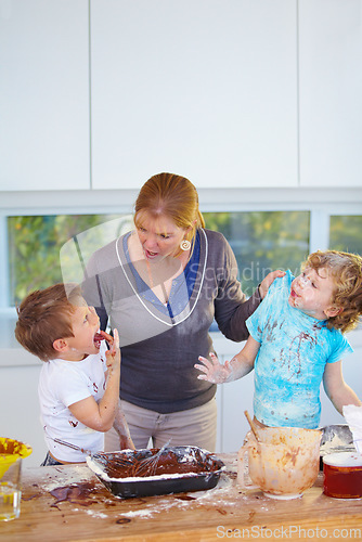 Image of Family, baking and a mother yelling at her children for the mess in a home kitchen with naughty boys. Food, cake or ingredients with a woman scolding her kids while cooking in an untidy apartment