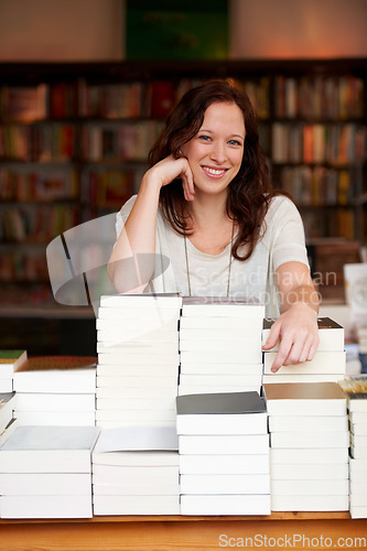 Image of Woman, bookshop business owner and smile in portrait by stack for discount, sale or pride for promotion. Entrepreneur, library and happy for retail deal, literature or knowledge for learning in store