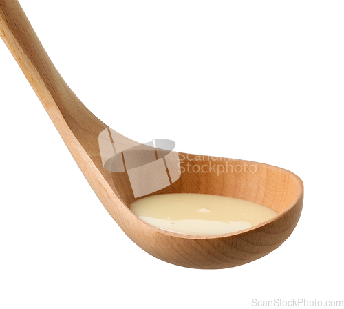Image of condensed milk in wooden ladle