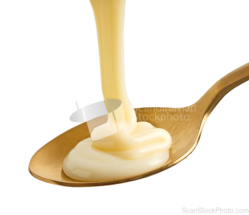 Image of condensed milk in golden spoon