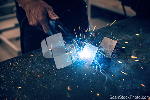Image of Male worker hand welding steel rack