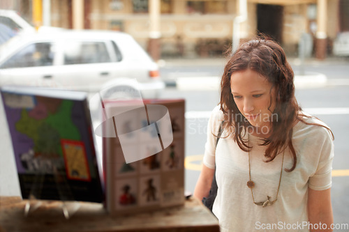 Image of Book store, window shopping and woman with retail sale, discount and customer with choice. City, town and sidewalk with a female person at shop and boutique for purchase, library and glass on road