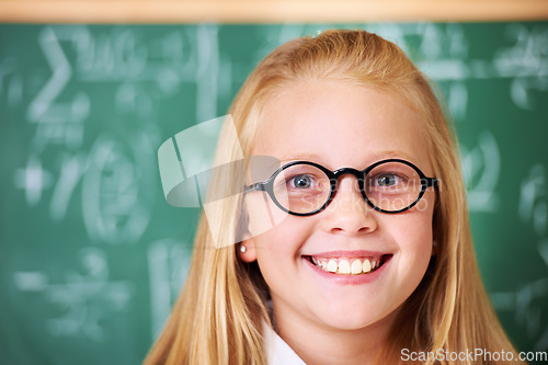 Image of Portrait of student, nerd and happy child by chalkboard in class for learning knowledge, education and study math. Face, glasses and smile of geek at school, girl or cute kid in classroom in Canada