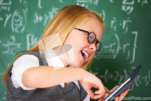 Image of child, student and calculator by chalkboard for happy education, learning and problem solving or solution. Smart girl or child with glasses and excited for school, typing numbers or math in classroom