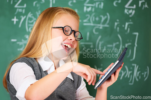 Image of Girl, calculator and happy for education, learning and problem solving or solution on chalkboard. Smart student, kid or child with glasses and excited for school, typing numbers and math in classroom