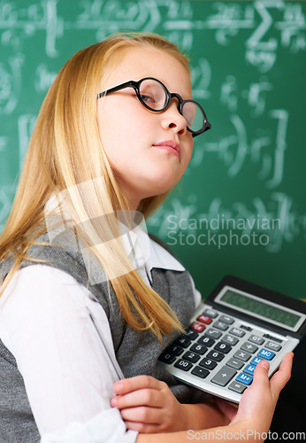 Image of GIrl, portrait and calculator by chalkboard for education, learning and problem solving or solution with confidence. Smart kid, student or child with glasses for school, numbers and math in classroom