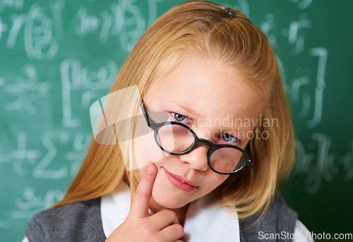 Image of Portrait of student, nerd and kid thinking by chalkboard in class for learning knowledge, education and study math. Face, glasses and geek at school, blonde girl and child in classroom in Switzerland