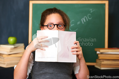 Image of Shock, reading and portrait of child with a book in the classroom for education, learning or knowledge. Study, nerd and girl kid with glasses enjoying a story or novel with surprise face at school.