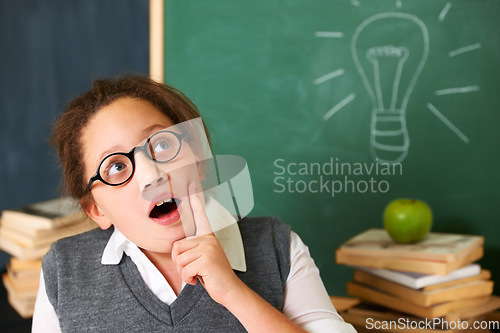 Image of Child, thinking and light bulb on chalkboard for education, learning and knowledge with wow, ideas or solution in classroom. Girl, student or school kid with vision, inspiration and lightbulb doodle