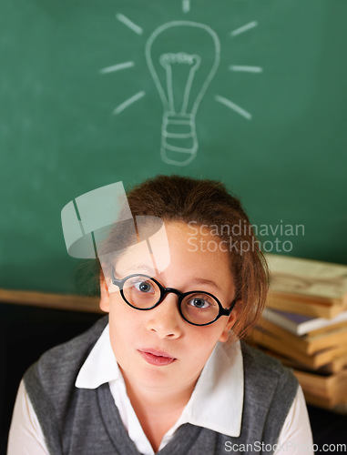 Image of Thinking, idea and portrait of student with light bulb on board for plan, decision or brainstorming in classroom. Education, learning and girl kid with drawing for choice, vision or future in school.