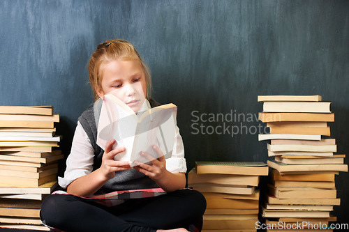 Image of Girl, classroom and child reading book for education, language learning and knowledge on chalkboard background. Kid or student on floor with books, library and story for school, English or literature