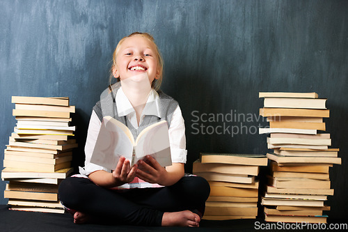 Image of Girl, classroom and kid reading book for education, language learning and knowledge on chalkboard background. Child or student on floor with books and story for school, English or literature portrait