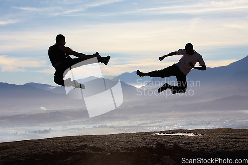 Image of Flying, kick and karate men on mountain top for fitness, training or body, speed or power on sky background. Martial arts, taekwondo or MMA friends in nature with jump, fighting or sports exercise