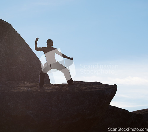 Image of Karate, fitness man on mountain top for body training, power or defense practice on blue sky background. Martial arts, MMA and male taekwondo master in nature for exercise, sports or morning cardio