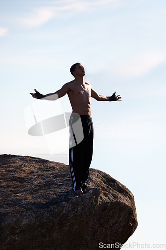 Image of Mountain top, freedom and fitness man with open arms in nature for training, wellness or sports on sky background. Exercise, success and athlete with morning cardio, gratitude or workout celebration