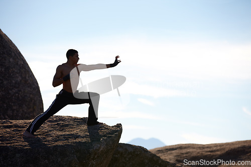 Image of Fitness, karate and man on mountain top for body training, power or defense practice on blue sky background. Martial arts, MMA and guy taekwondo master in nature for exercise, sport or morning mockup