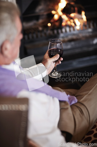 Image of Relax, senior man with wine at fireplace in hotel lounge or cozy room on retirement vacation. Luxury hospitality, elderly person with glass or drink at holiday accommodation with peace, calm and fire