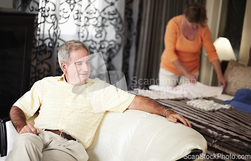 Image of Hotel, senior man and woman packing clothes in bedroom on retirement holiday chat together. Travel, vacation and happy old couple unpacking with bed, sofa and relax with luxury hospitality in room.