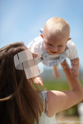 Image of Woman, lift baby outdoor and happy with care, love and bonding on holiday, summer sunshine and playing together. Mother, infant child and comic laughing in backyard, park or family garden in spring