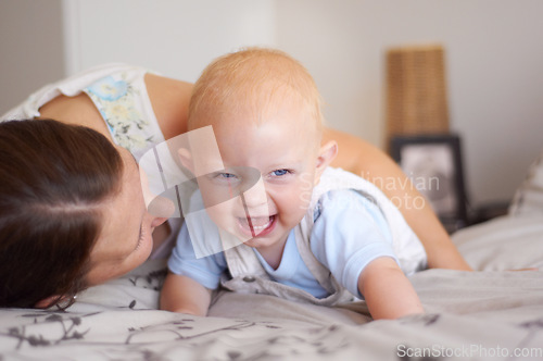 Image of Happy, playing and a baby with mother on a bed for bonding, laughing and fun together. Smile, love and a family, child or mom in the bedroom for care, funny and playful in a house with a joke