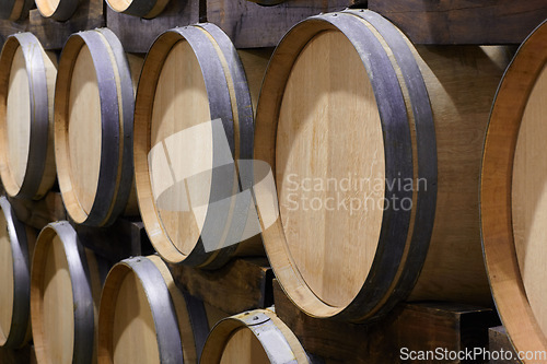 Image of Background, wine cellar and barrel in brewery for beer production, alcohol manufacturing or whiskey fermentation. Closeup, wood cask container or liquor storage in winery, factory or distillery vault