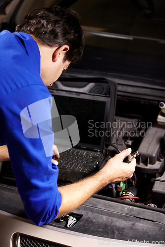 Image of Car, diagnostic or repair and a mechanic man in a workshop as an engineer looking at the engine of a vehicle. Garage, report or service with a young technician working under the hood of an automobile