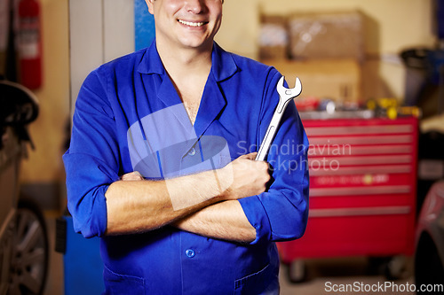 Image of Happy man, arms crossed and hands of mechanic with spanner to repair, maintenance and auto service. Confident technician, wrench and tools to fix, inspection and professional at garage or workshop