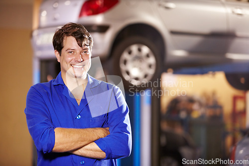 Image of Happy, portrait and a mechanic with arms crossed in a workshop for pride in a car. Smile, working and a man in a garage for work, maintenance or building a vehicle for transportation or inspection