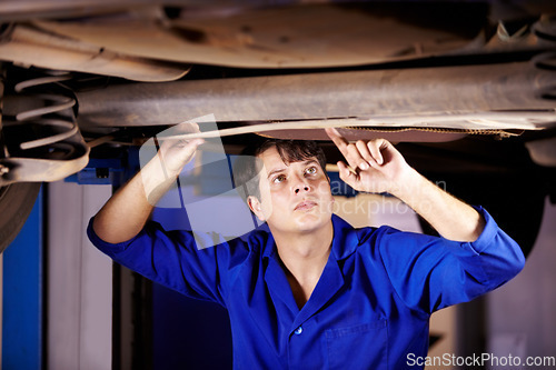 Image of Car, inspection or service with an engineer man in a garage for a report on a vehicle repair for insurance. Maintenance, professional and expertise with a young mechanic in a workshop for assessment