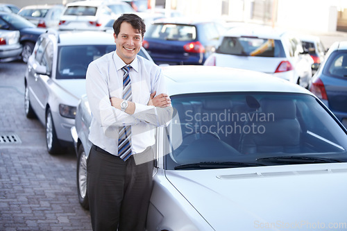 Image of Portrait, luxury and a man arms crossed at a dealership for car sale in a commercial parking lot. Business, smile and automobile trade with a happy young salesman outdoor for transport service