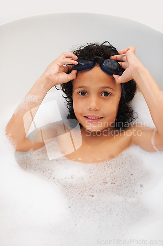 Image of Portrait, kids and bath with a boy in goggles while cleaning his skin in the home for natural hygiene. Face, children and a happy young kid in the bathroom to wash with soap in water from above