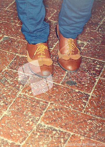 Image of Shoes, fashion and closeup of man feet by brick floor for an elegant, stylish and trendy outfit. Legs, footwear and zoom of male person with luxury, classy and expensive style with jeans by pavement.