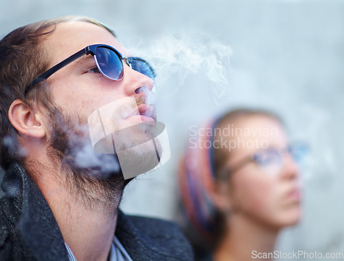 Image of Face, man and woman smoking outdoor with sunglasses for experience, relax and cigarette enjoyment. People, hipster and smoke for trend, exhale or tobacco satisfaction with shades and confidence