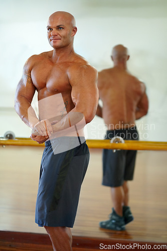 Image of Man, strong arm and flex in mirror at gym with fitness, workout and exercise of bodybuilder with reflection. Muscle, person and athlete with sport training, wellness and body builder at a health club