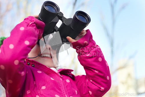 Image of Binoculars, nature and child for explore, discovery and looking on adventure outdoors. Travel, winter and happy, young and excited girl search on holiday, vacation and freedom on weekend for camping