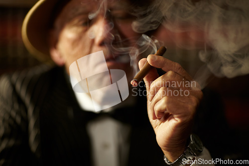 Image of Old man, smoking and cigarette in hand with smoke and crime boss of mob with a decision. Gangster, face and senior person with vintage cigar in mafia or country club with luxury, vice or habit