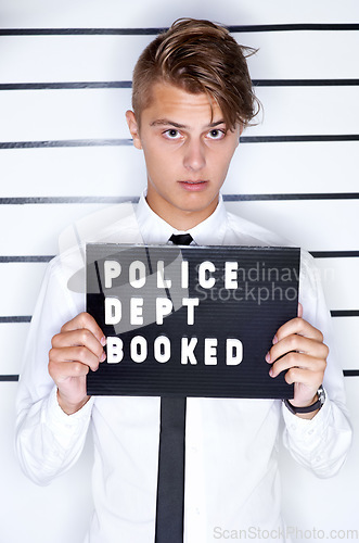 Image of Crime, mugshot and portrait of man on a white background for suspect for criminal, illegal and fraud activity. Police station, height chart and person with signboard for arrested, wanted and convict