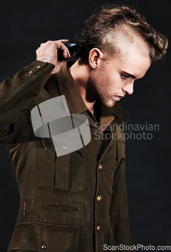 Image of Military, soldier and man shaving hair in studio isolated on black background. Army, serious and person shave head with clipper machine in profile for haircut to prepare for service, bootcamp or war