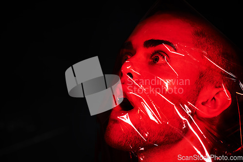 Image of Man, red plastic and suffocate in studio isolated on a black background mockup. Polyethylene, film and person with depression, fear and anxiety, stress and mental health crisis, psychology and neon