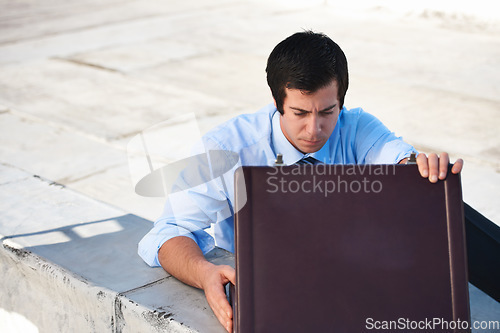 Image of Suitcase, rooftop and businessman on a building in the city searching or looking for work bag. Corporate career, balcony and professional male lawyer with briefcase for legal documents in urban town.